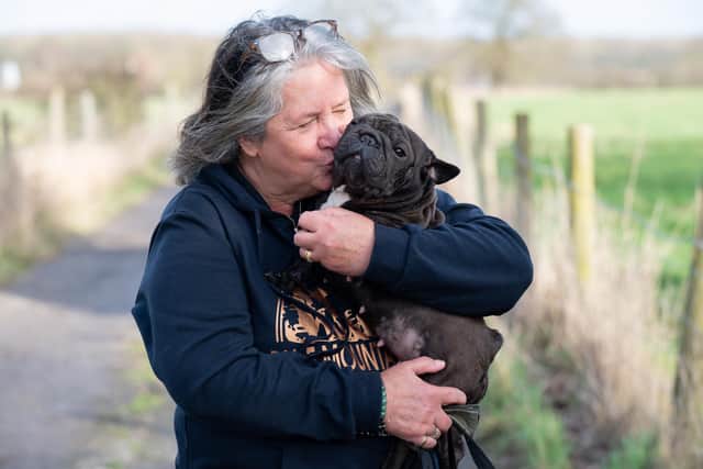 Dog courier Meg hugs pet French Bulldog Minnie