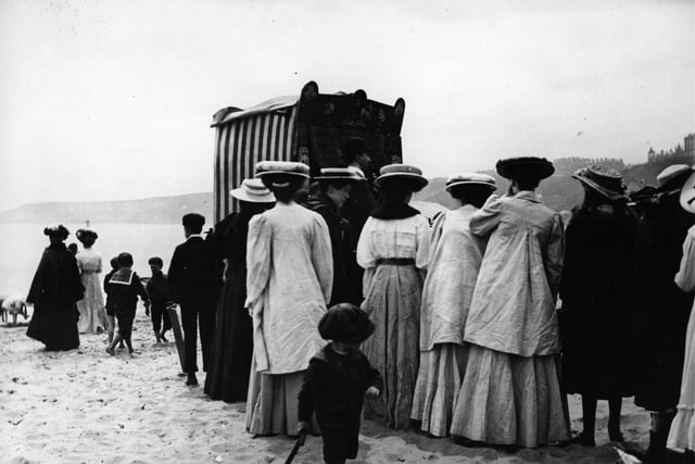 Crowds gather to watch a Punch and Judy puppet show on the beach at Scarborough in June 1908.