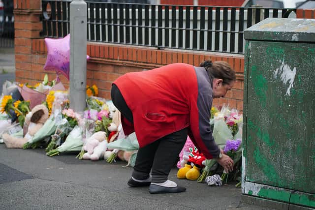 A woman lays flowers near to the scene of an incident in Kingsheath Avenue, Knotty Ash, Liverpool, where nine-year-old Olivia Pratt-Korbel was fatally shot on Monday night. The people of Liverpool have been urged to turn in the masked gunman who killed Olivia as he chased his intended target into her home. Picture date: Wednesday August 24, 2022.