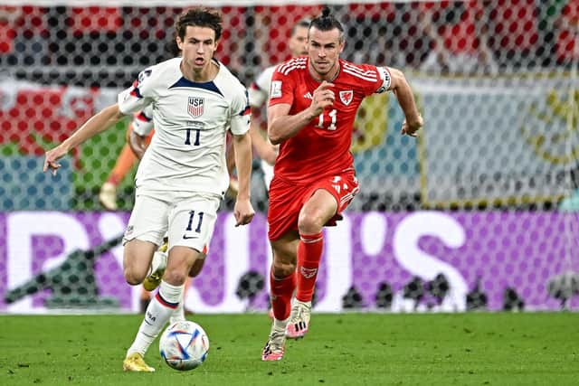 Familiar faces: USA midfielder Brenden Aaronson, left, leaves Wales' forward Gareth Bale in his wake during the two nations' Qatar 2022 World Cup Group B opener at the at the Ahmad Bin Ali Stadium in Al-Rayyan (Picture: Anne-Christine POUJOULAT / AFP)