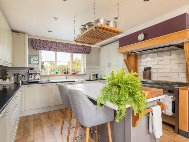 Granite worktops surround a central island, while French doors open towards the garden.