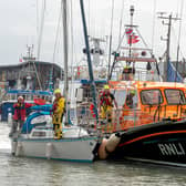 A yacht safely arrives back in Bridlington harbour with the Bridlington all-weather lifeboat.