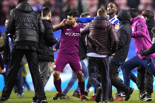 FLASHPOINT: Manchester City's Sergio Aguero is surrounded by fans as he attempts to leave the pitch after his team's 1-0 FA Cup defeat to Wigan Athletic at the DW Stadium in February 2018. Picture: Gareth Copley/Getty Images