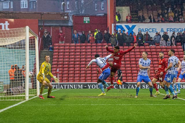 Barnsley's Jonathan Lewis bundles in a late equalising goal versus Cambridge. Photo: Tony Johnson.