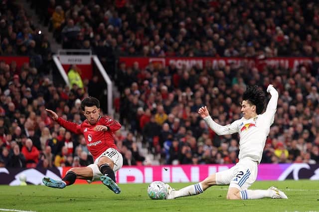 DENIED: Lisandro Martinez  slides in to stop Ao Tanaka scoring Leeds United's third (Image: Carl Recine/Getty Images)