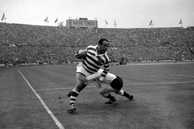 Legendary rugby league star Sir Billy Boston bursts through a tackle during a Rugby League Challenge Cup Final at Wembley.