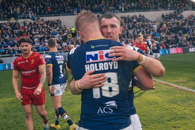 Tom Holroyd celebrates Rhinos' win over Catalans with teammate Cameron Smith. (Picture by Alex Whitehead/SWpix.com)