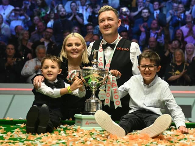England's Kyren Wilson poses with the trophy, his wife Sophie and his sons Bailey (L) and Finley (R) after victory over Wales' Jak Jones. (Photo by OLI SCARFF/AFP via Getty Images)