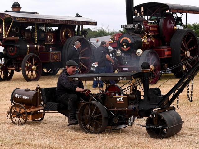 A miniature steam-powered road roller is put through its paces, with full-size traction engines providing an impressive backdrop