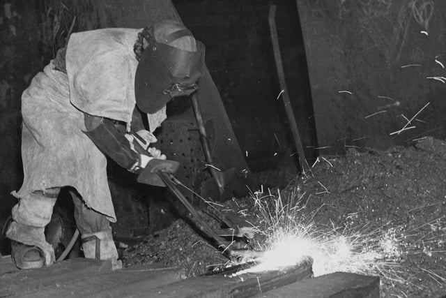A female steel foundry worker in full protective clothing uses an oxy ferraline torch to weld in January 1943 at the Park Gate Iron and Steel Company in Rotherham.