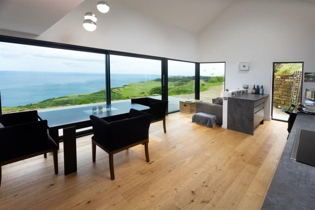 The modern, open plan kitchen diner, with electric 2 oven AGA and integrated appliances, has triple aspect, large feature windows as well as a wide sliding door onto a spacious patio taking full advantage of the stunning coastline views.