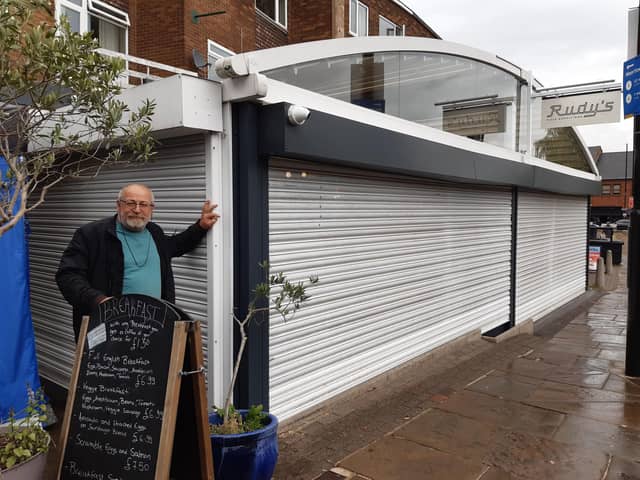 Owner of the Mad Greek, Kostas Tsiknakis, says that the shutters erected by Rudy's are costing him business