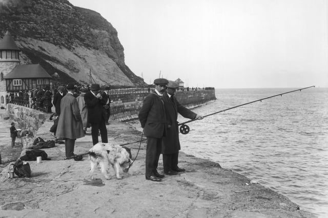 circa 1912:  A group of men sea angling from the harbour at Scarborough.