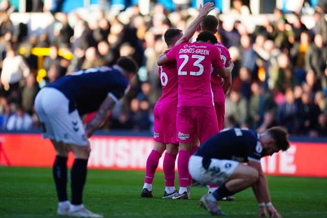 HOPE: Huddersfield Town's players celebrate as Millwall's players sink to their knees at the final whistle at The Den Picture: Victoria Jones/PA