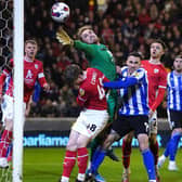 TEAM WORK: Barnsley goalkeeper Harry Isted (centre) makes a save during Tuesday's 4-2 win over Sheffield Wednesday at Oakwell. Picture: Tim Goode/PA