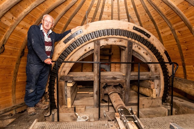 Chris Tippin, one of the volunteers at Holgate Windmill, standing next to the break wheel in the cap of the mill.
