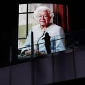 A person stands along the Las Vegas Strip as an image of Queen Elizabeth II is shown on a casino marquee Thursday, Sept. 8, 2022, in Las Vegas. (AP Photo/John Locher)