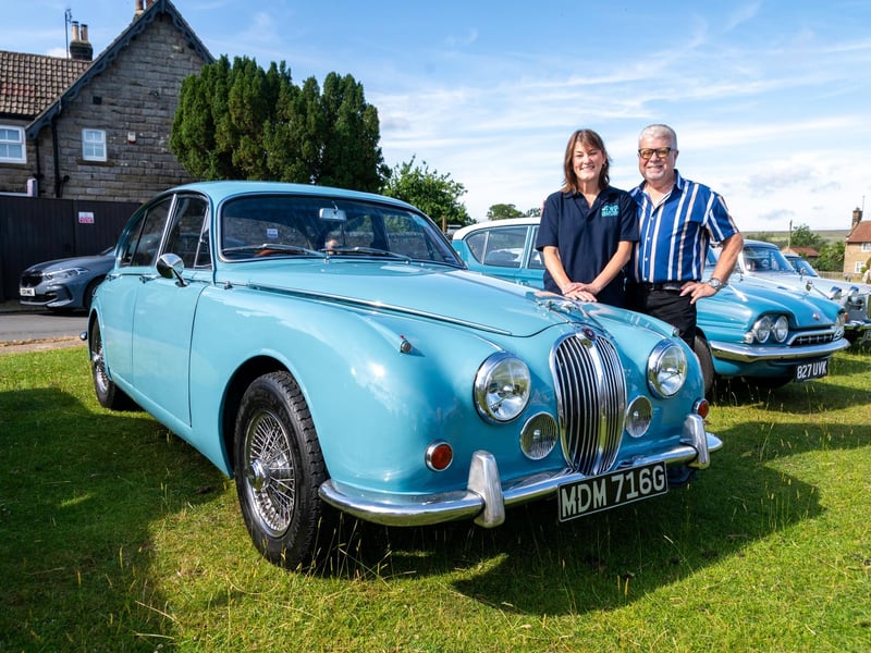 Sarah Walker, the daughter of Peter Walker AKA Nicholas Rhea, author of Heartbeat, next to her late father's 1969 Jaguar MKII.