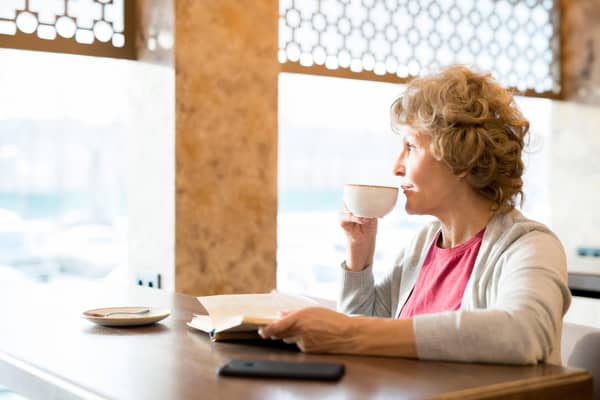 A woman reading a book in a coffee shop. PIC: Alamy/PA.