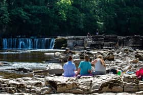 People enjoying the warm weather beside the River Swale at Richmond Falls. Picture Bruce Rollinson