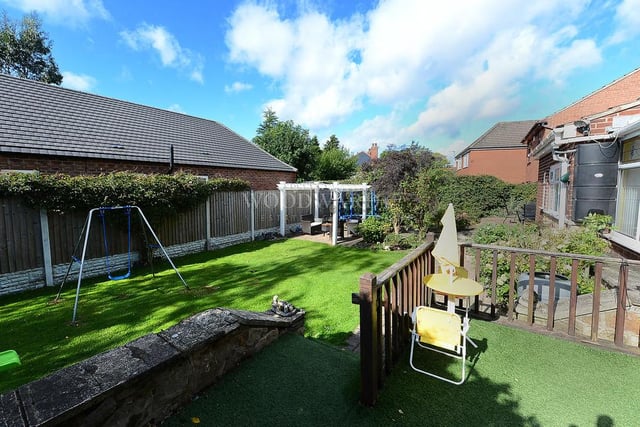 The back garden is not only pleasant but also has lots of personality. There are a couple of patio areas, as well as a lawn, and the whole garden is enclosed thanks to fenced boundaries.