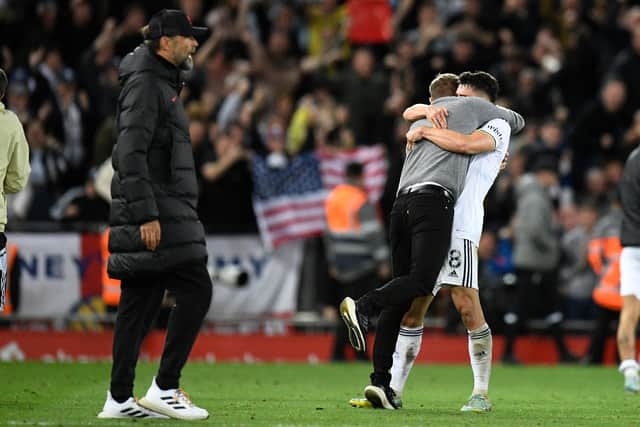 Leeds United's English striker Patrick Bamford (R) and Leeds United's US head coach Jesse Marsch (2R) hug as Liverpool's German manager Jurgen Klopp (L) walks by after the final whistle of the English Premier League football match between Liverpool and Leeds United at Anfield in Liverpool, north west England on October 29, 2022. (Photo by OLI SCARFF/AFP via Getty Images)