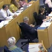 A Labour councillor has been asked to give a formal apology by the opposition after using his phone during a meeting of full council.