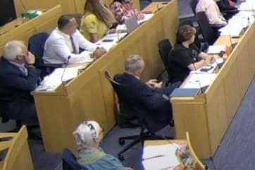 A Labour councillor has been asked to give a formal apology by the opposition after using his phone during a meeting of full council.
