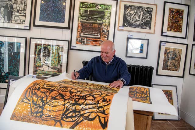 Printmaker Ian Burke signing his work at the Staithes Gallery