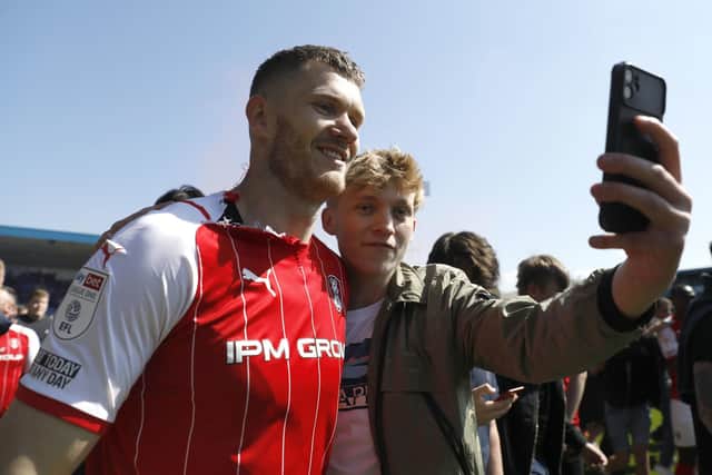 ECSTASY: Michael Smith (left) poses for a photo with a fan after the final whistle after Rotherham United secure promotion at Gillingham's Priestfield Stadium