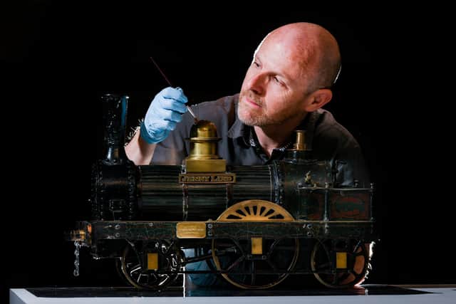 Pictured John McGoldrick, Curator of Industrial History for Leeds Museums and Galleries, brushing down a Model of an E.B. Wilson steam locomotive 'Jenny Lind'.