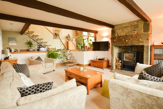 The sensational sitting room with wood-burning stove and a contemporary staircase