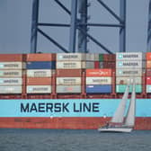 A yacht sailing past the container ship Vuoksi Maersk being loaded at the Port of Felixstowe, in Felixstowe, Suffolk, seen from Harwich, Essex. At least 10,000 jobs are being axed worldwide at global shipping giant AP Moller Maersk amid a slump in demand for container freight. Picture: Yui Mok/PA Wire