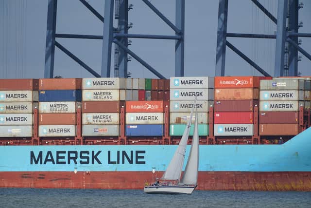 A yacht sailing past the container ship Vuoksi Maersk being loaded at the Port of Felixstowe, in Felixstowe, Suffolk, seen from Harwich, Essex. At least 10,000 jobs are being axed worldwide at global shipping giant AP Moller Maersk amid a slump in demand for container freight. Picture: Yui Mok/PA Wire