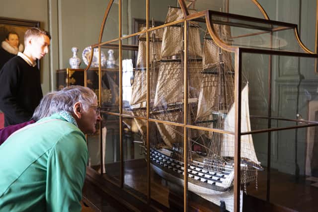 Visitors admiring the Napoleonic ship model in the Court Room at Treasurer's House, York. By Annapurna Mellor/National Trust