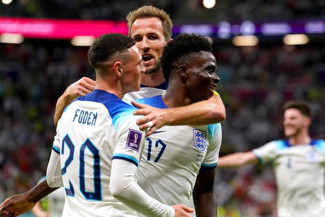 MAGICAL NIGHT: England's Bukayo Saka (right) celebrates with team-mates Phil Foden and Harry Kane after scoring their side's third goal of the game againt Senegal at the Al-Bayt Stadium. Picture: Martin Rickett/PA
