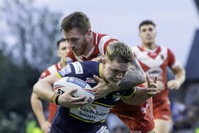 Leeds' James McDonnell is tackled by Salford's Marc Sneyd. (Photo: Allan McKenzie/SWpix.com)