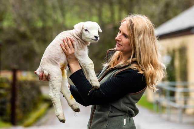 Farmer/Shepherdess Heather Challis, 27, of Halfway House Farm, Middlesmoor, Lofthouse, near Pateley Bridge, North Yorkshire, holding one of their new born lambs. Picture By Yorkshire Post Photographer,  James Hardisty. Date:20th March 2023.
