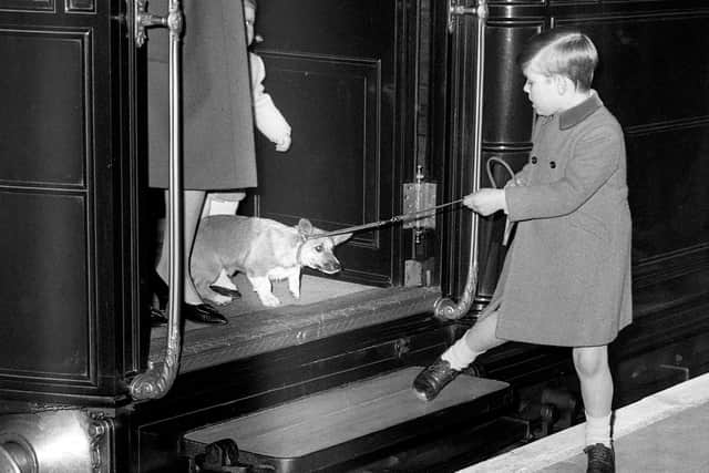 Prince Andrew and one of his mother's corgis leave a train at London Liverpool Street Station in 1966