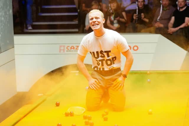 File photo dated 17-04-2023 of A Just Stop Oil protester after jumping on the table and throwing orange powder. Former World Snooker chairman Barry Hearn has called for tougher punishments for protesters after play was disrupted at the World Championship in Sheffield.