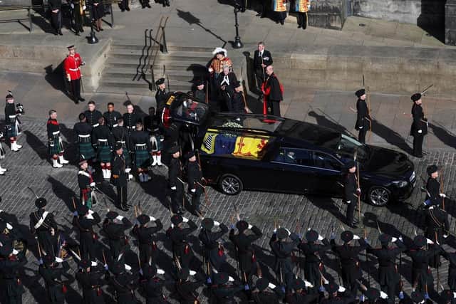 Pallbearers wait to carry the coffin of Britain's Queen Elizabeth II as the hearse arrives at St. Giles' Cathedral after the procession from the Palace of Holyrood House. (Pic credit: Russell Cheyne / Getty Images)