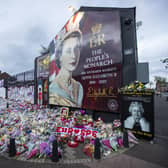 Members of the public visit a mural to Queen Elizabeth II on the Shankill Road in Belfast ahead of the national minute's silence in memory of Queen Elizabeth II on Sunday. A separate event on Monday saw hundreds of people gather outside Belfast City Hall to watch the funeral.