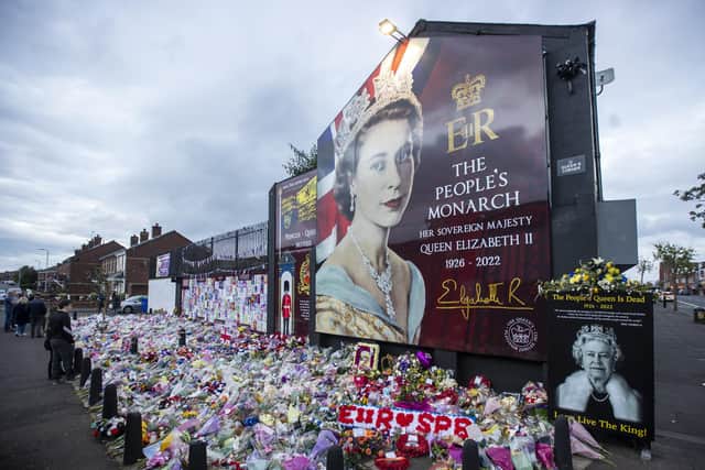 Members of the public visit a mural to Queen Elizabeth II on the Shankill Road in Belfast ahead of the national minute's silence in memory of Queen Elizabeth II on Sunday. A separate event on Monday saw hundreds of people gather outside Belfast City Hall to watch the funeral.