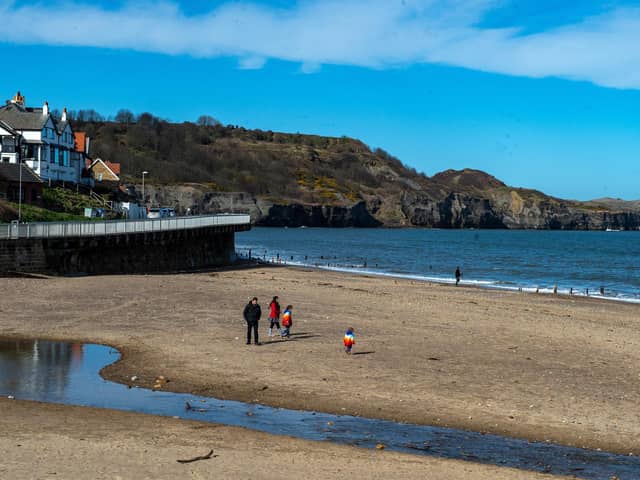 Walkers on the beach at Sandsend make the most of the good weather