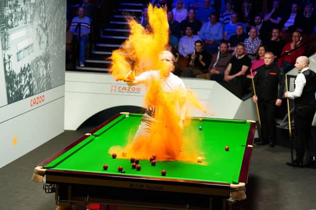 Just Stop Oil protester Eddie Whittingham jumping on the table during the match between Robert Milkins against Joe Perry during day three of the Cazoo World Snooker Championship at the Crucible Theatre, Sheffield in 2023. Photo by Mike Egerton/PA Wire.