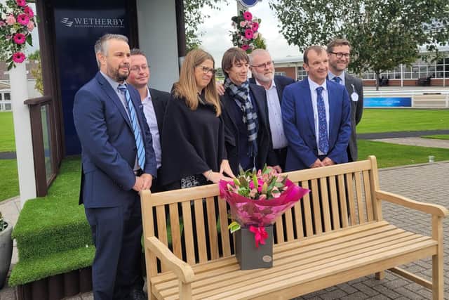 Lizzie Richmond, third from the left, and former colleagues of Tom Richmond at the bench that bears a plaque in his name.