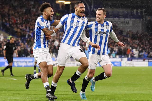 HUDDERSFIELD, ENGLAND - APRIL 11: Jon Russell of Huddersfield Town celebrates with team mates Sorba Thomas and Harry Toffolo after scoring their sides first goal during the Sky Bet Championship match between Huddersfield Town and Luton Town at John Smith's Stadium on April 11, 2022 in Huddersfield, England. (Photo by Charlotte Tattersall/Getty Images)