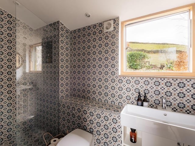 An en suite shower room has a walk-in shower and Moroccan-inspired tiles.