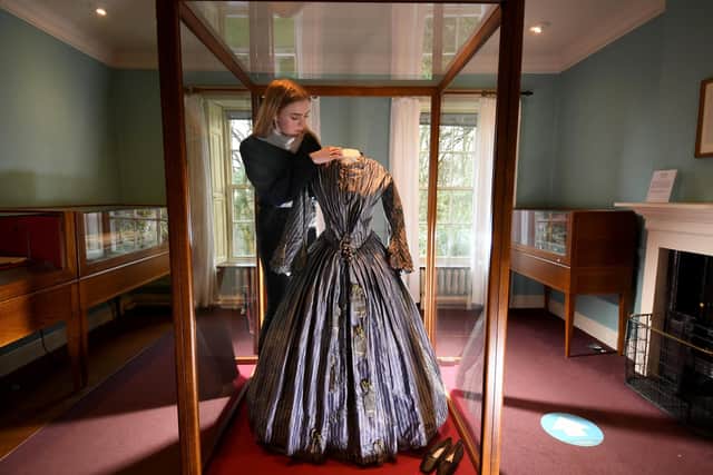 Exhibition of Charlotte Bronte clothing items at the Bronte Parsonage, Haworth..Deputy Visitor Experience Manager Emma Littlejohns is pictured with a Striped Silk Dress worn by Charlotte Bronte.