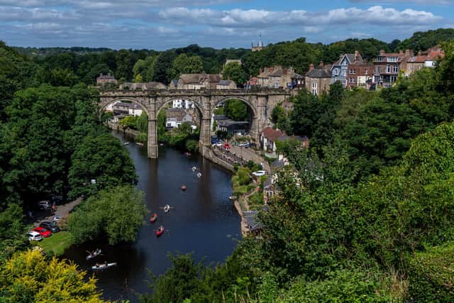 Families enjoying the weather by hiring boats on the River Nidd, under the magnificent Knaresborough Railway viaduct in North Yorkshire.